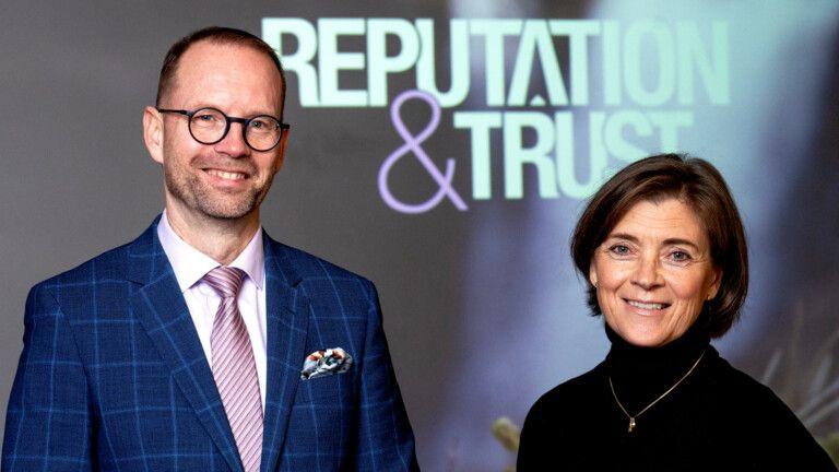 T-Medias administrerende direktør Harri Leinikka til venstre og seniorrådgiver Nina Ehrnrooth til højre. Bag dem ses Reoutation&amp;Trust-logoet.