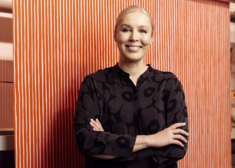 Tiina Alahuhta-Kasko står foran Marimekos rødstribede stof.