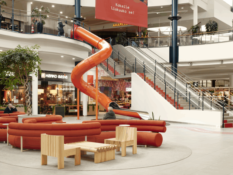 På billedet ses en orange rutsjebane i et indkøbscenter.
